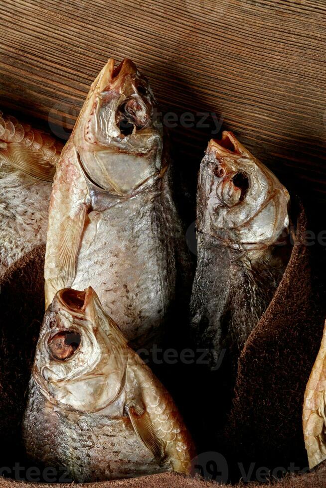 Ssalted air-dried fish wrapped in genuine leather on wooden background photo