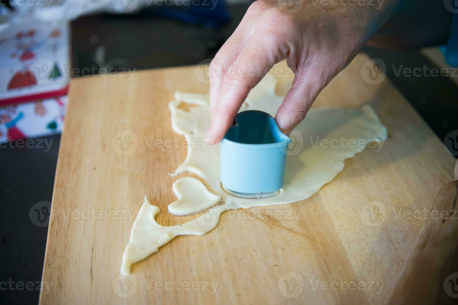 Woman hand making heart shaped cookies photo