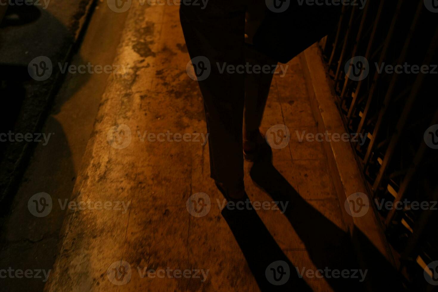 Silhouette of woman's legs walking in the dark in the middle of the night photo