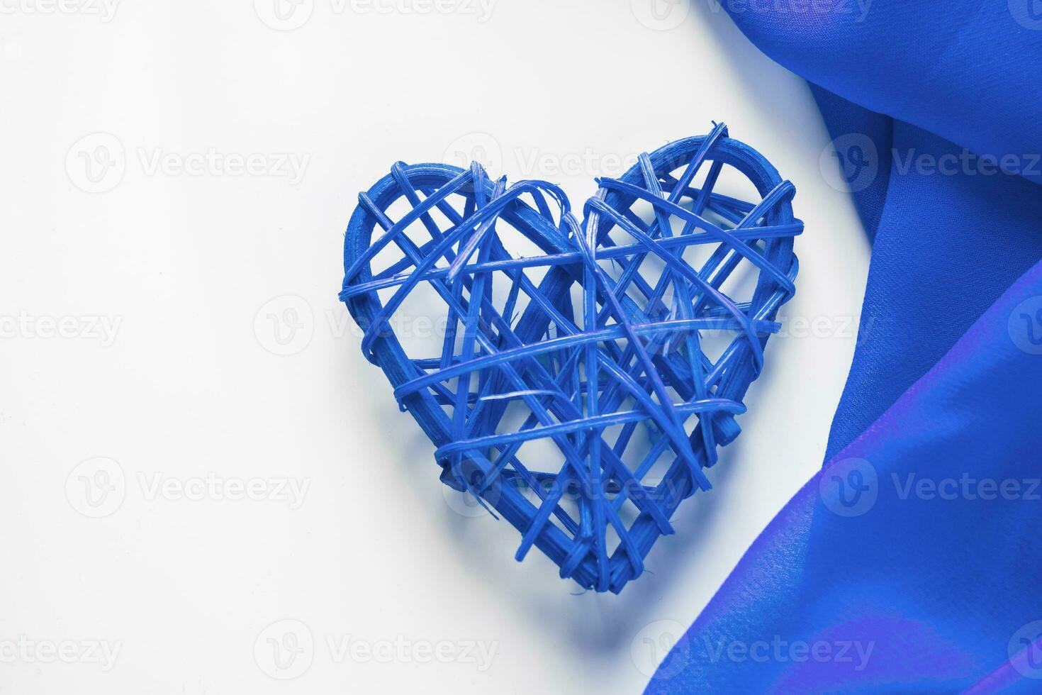 Blue heart and silk ribbon on a white background photo