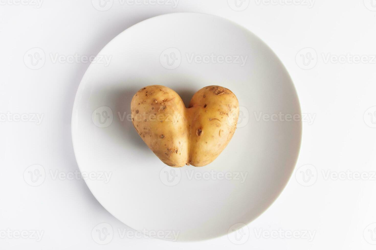 Heart shaped potatoes on a white plate. Valentine's day concept. Ugly food. photo