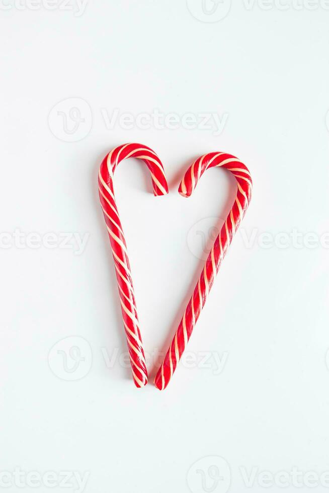 Two Christmas candy canes in the shape of a heart. Valentine's day concept. Place for text. photo