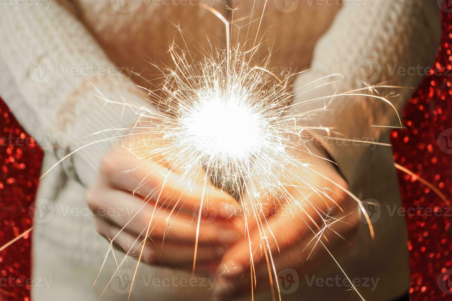 nuevo año celebracion. joven mujer sostiene bengala en su manos. Navidad noche. brillante chispas de fuego foto