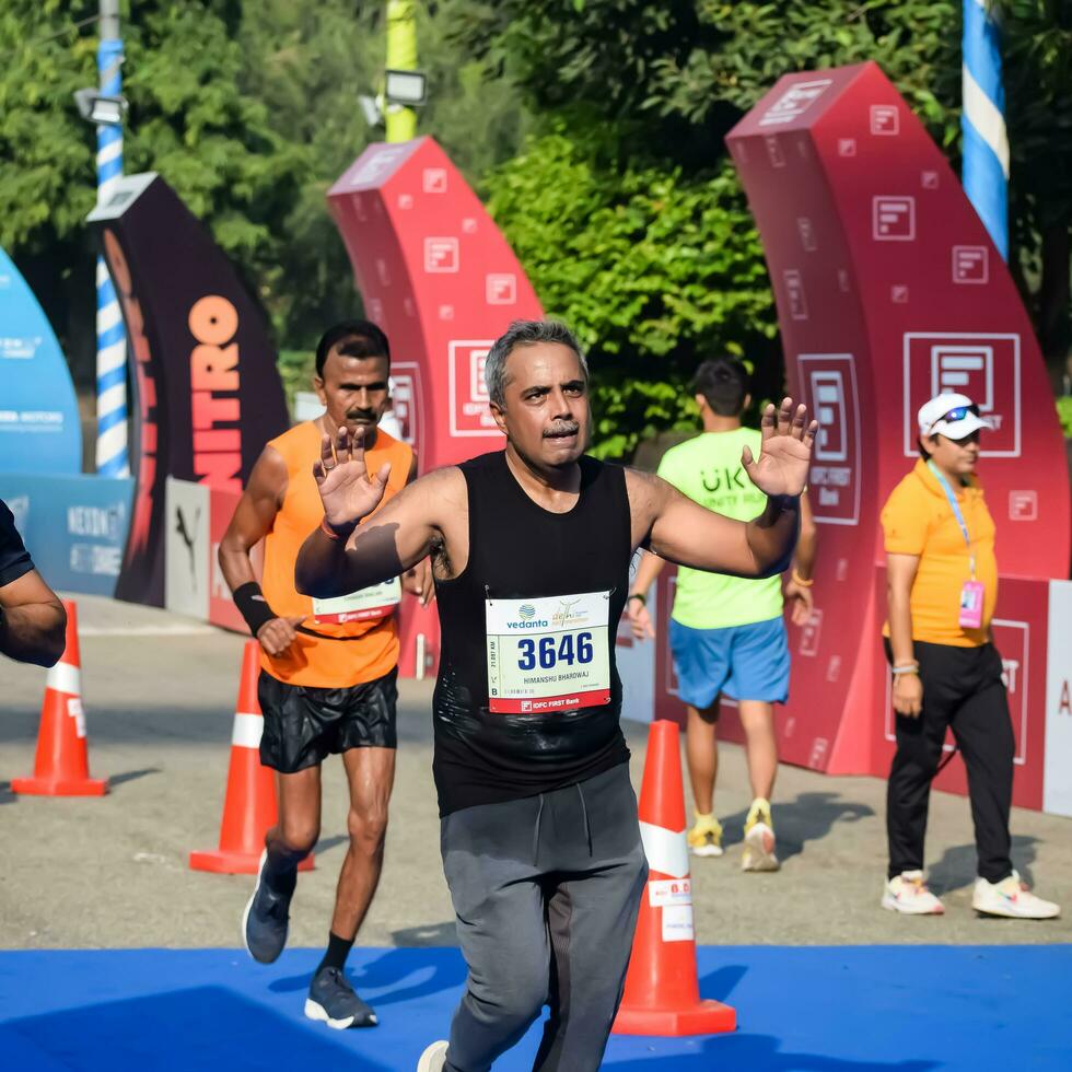 nuevo Delhi, India - octubre 15 2023 - vedanta Delhi medio maratón carrera después codicioso en cuales maratón Participantes acerca de a cruzar el terminar línea, Delhi medio maratón 2023 foto