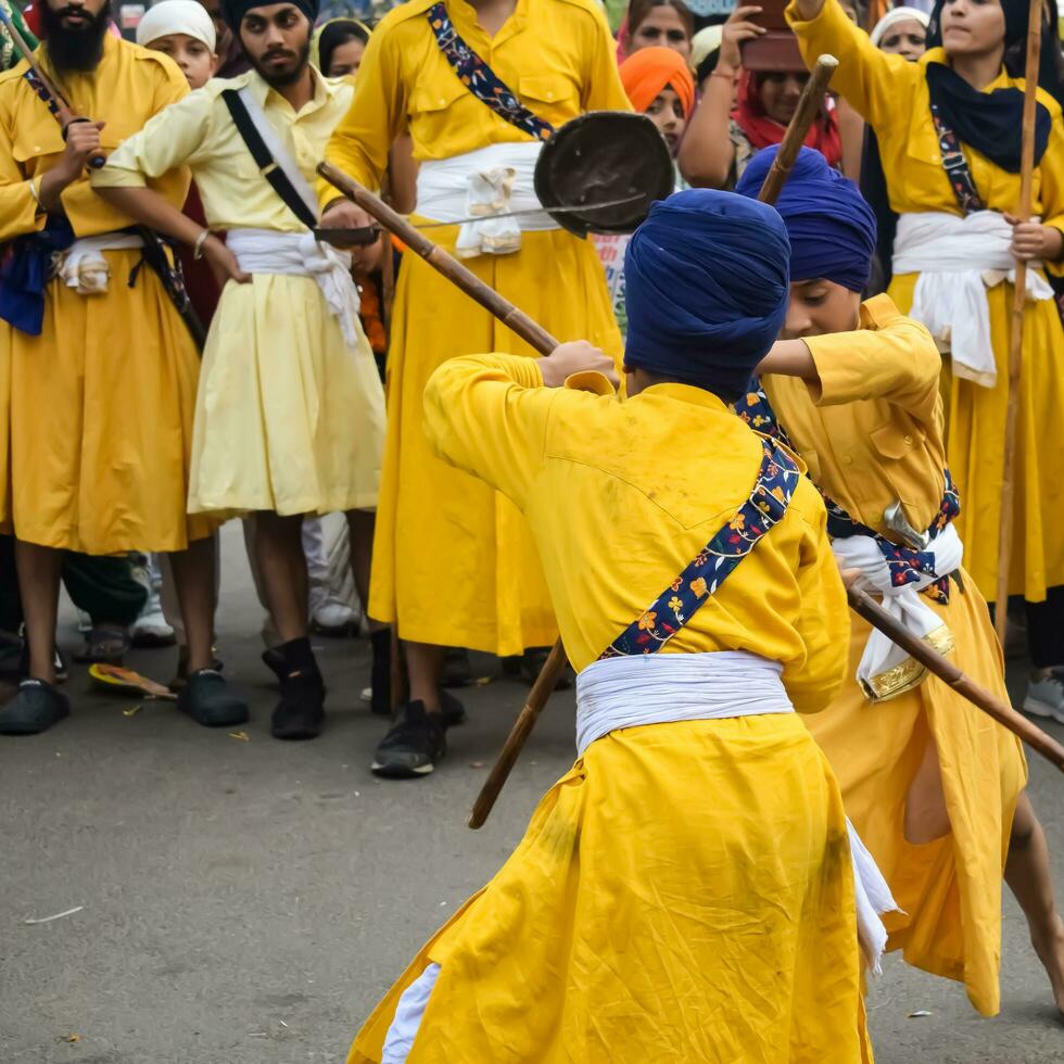 Delhi, India, October 2, 2023 - Sikhs display gatka and martial arts during annual Nagar Kirtan, Traditional, procession on account of birthday of Guru Nanak Dev ji, Nagar Kirtan in East Delhi area photo