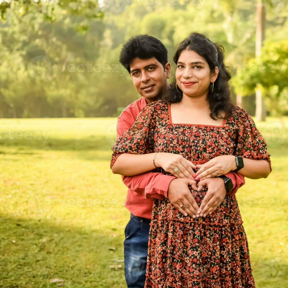 indio Pareja posando para maternidad disparar actitud para acogedor nuevo nacido bebé en lodhi la carretera en Delhi India, maternidad foto disparar hecho por padres para acogedor su niño, pre bebé foto disparar