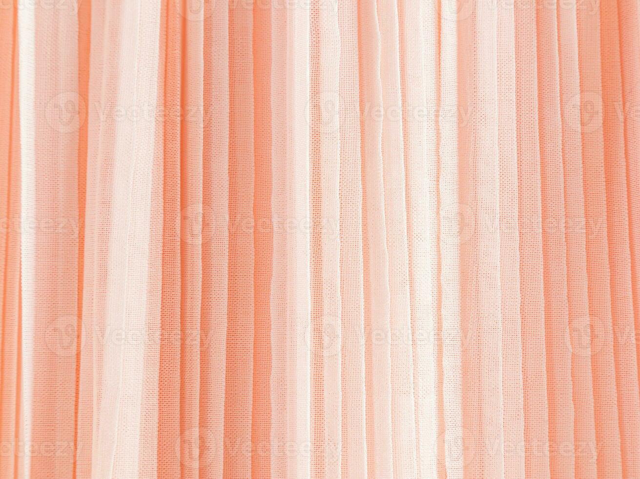 Abstract background of soft pleats of peach color quilled fabric. Festive background for design. A copy space. Color of the Year 2024 Peach Fuzz photo