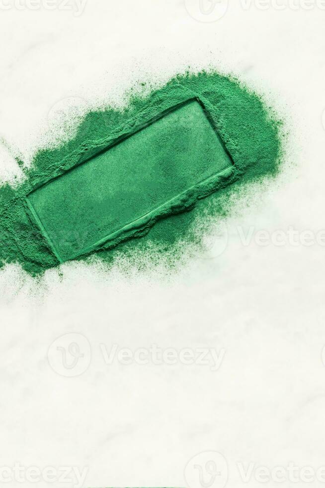 Scattered natural spirulina green algae powder on white background with highlighted space for text. blank lay for text, product presentation. photo