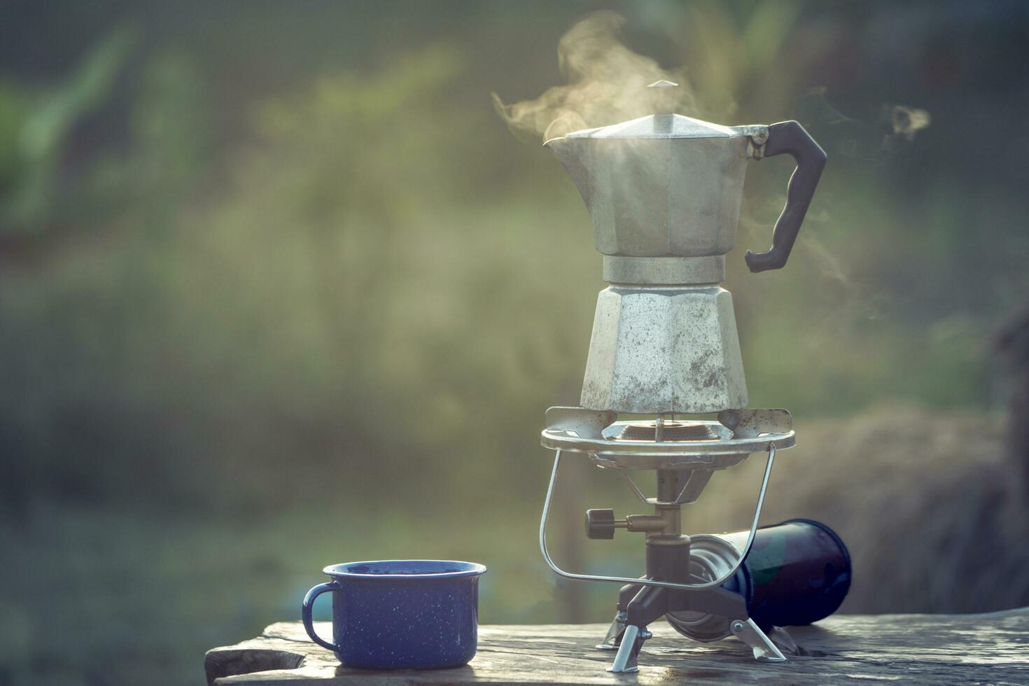 Moka pot and smoke, coffee bask on fire, In the forest at sunrise in the morning. soft focus. shallow focus effect. photo