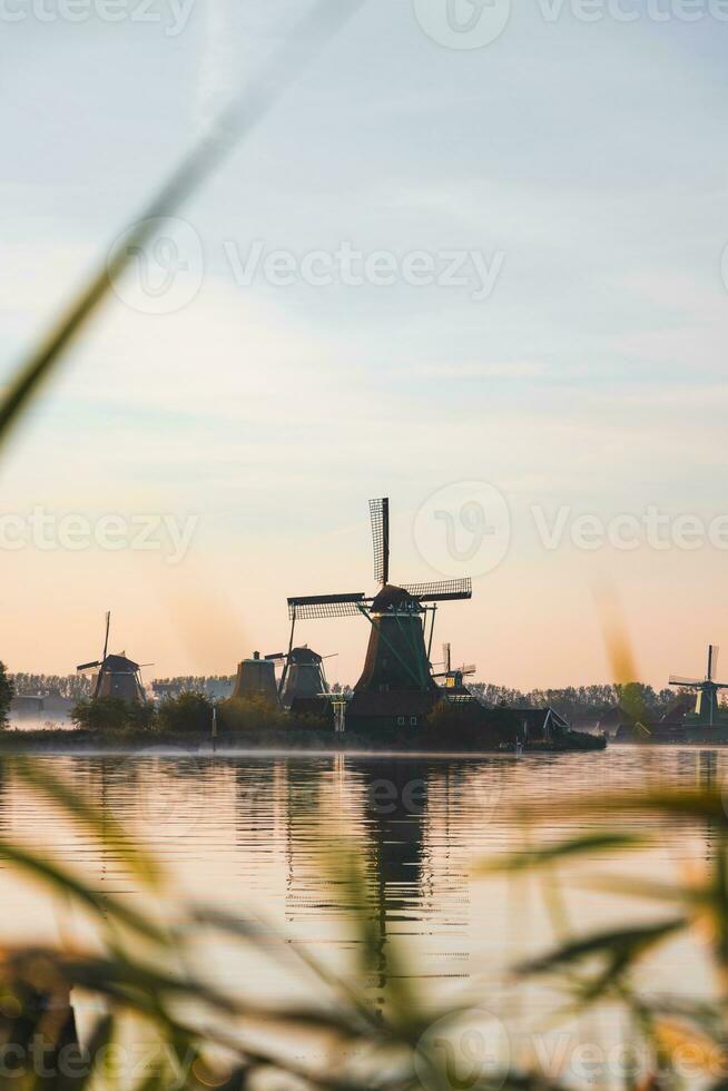 Popular tourist spot Zaanse Schans is near Amsterdam in the west of the Netherlands. Historical, realistic windmills during sunrise. Holland's landmark photo