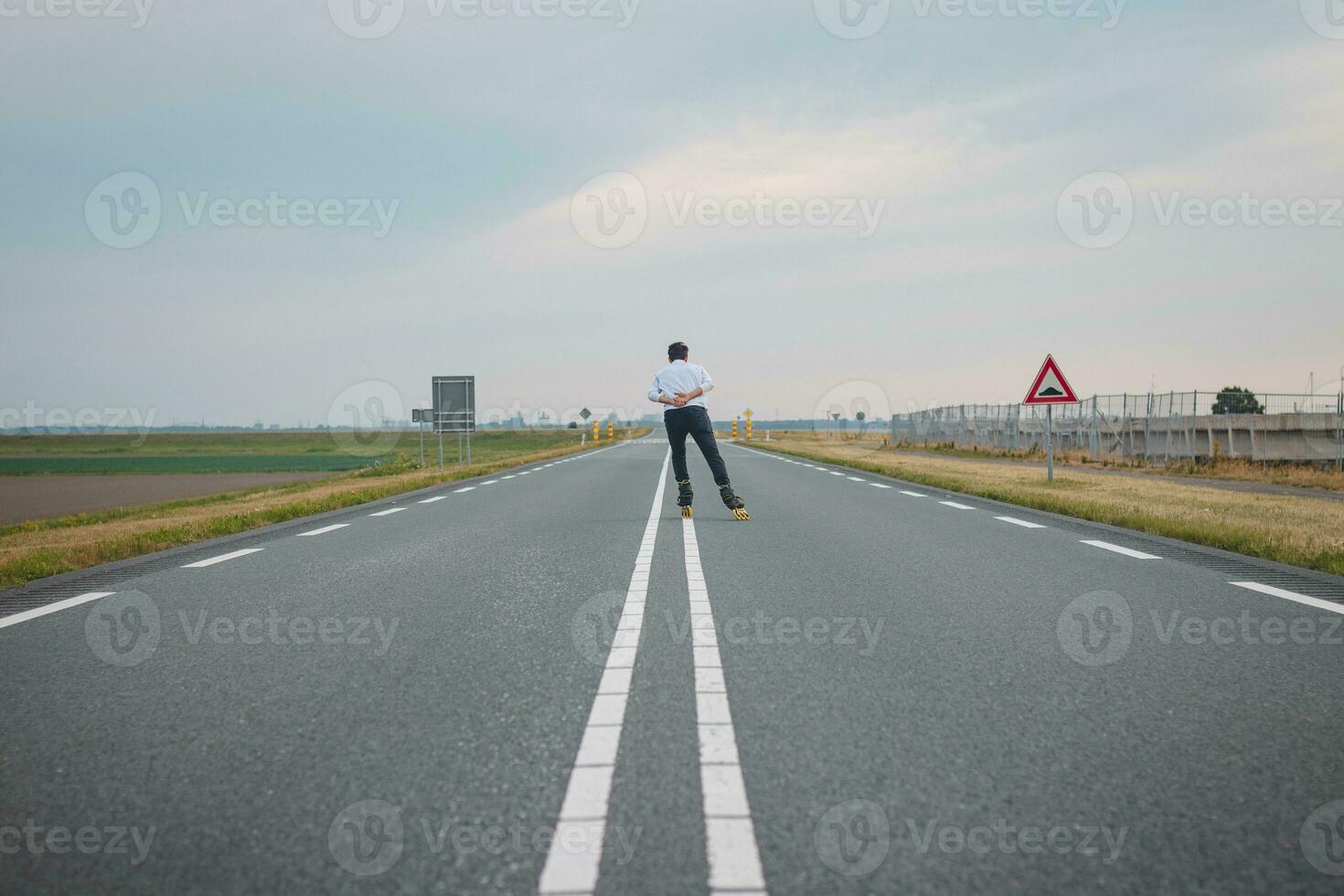 hermoso joven atleta patines en holandés carreteras a mejorar resistencia y aptitud física. un joven hombre trenes estabilidad y disfrutando el Fresco aire foto