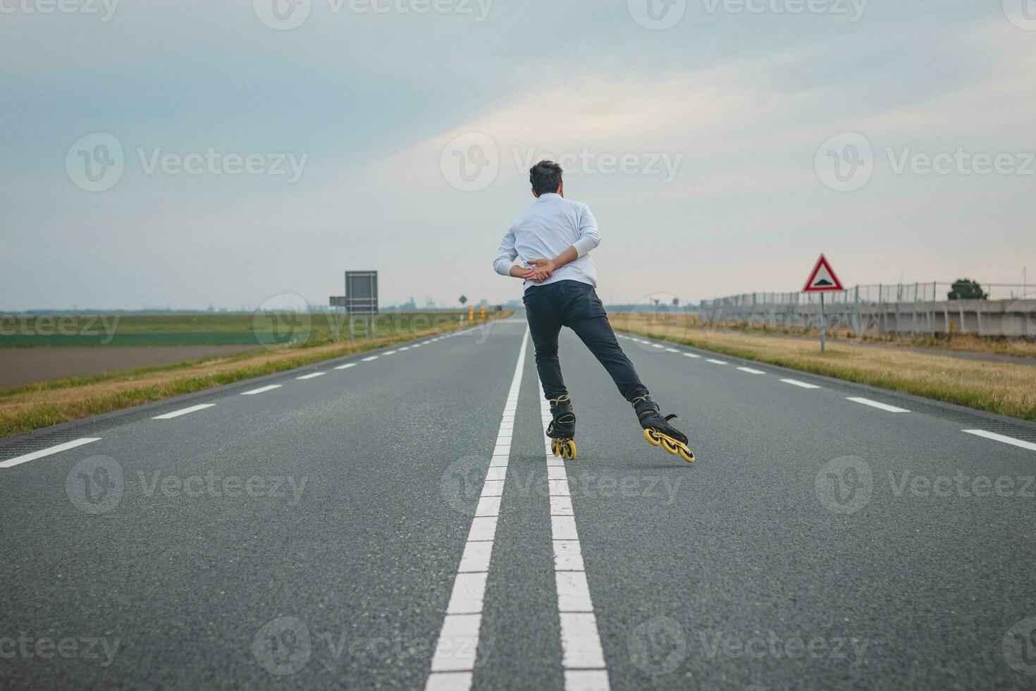 Handsome young athlete rollerblades on Dutch roads to improve endurance and fitness. A young man trains stability and enjoying the fresh air. Sport lifestyle photo