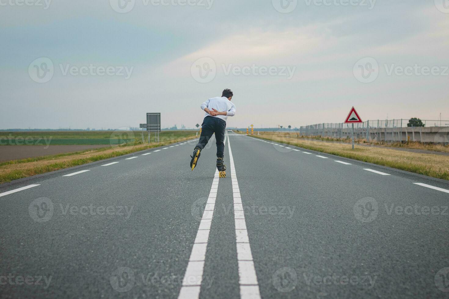 Handsome young athlete rollerblades on Dutch roads to improve endurance and fitness. A young man trains stability and enjoying the fresh air. Sport lifestyle photo