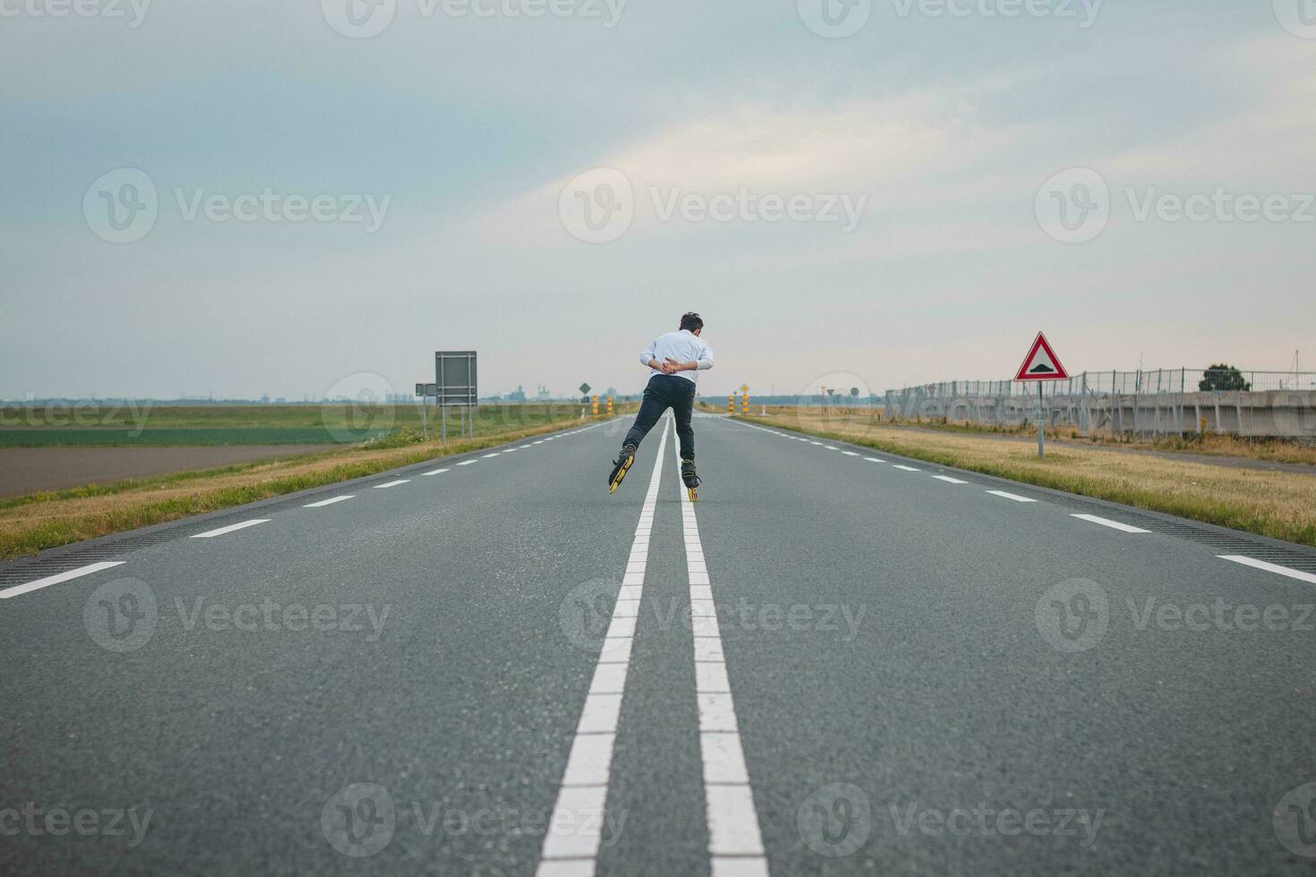 Handsome young athlete rollerblades on Dutch roads to improve endurance and fitness. A young man trains stability and enjoying the fresh air photo