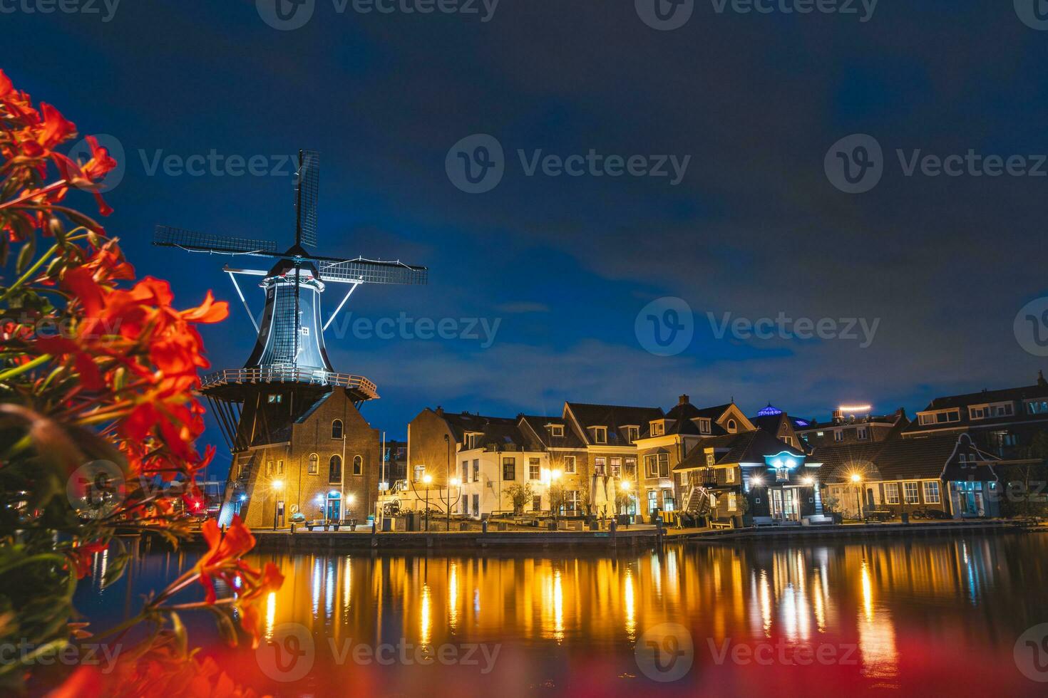 Night view of Haarlem city centre with the illuminated historic mill and buildings. Typical Dutch architecture. Exploring Holland photo
