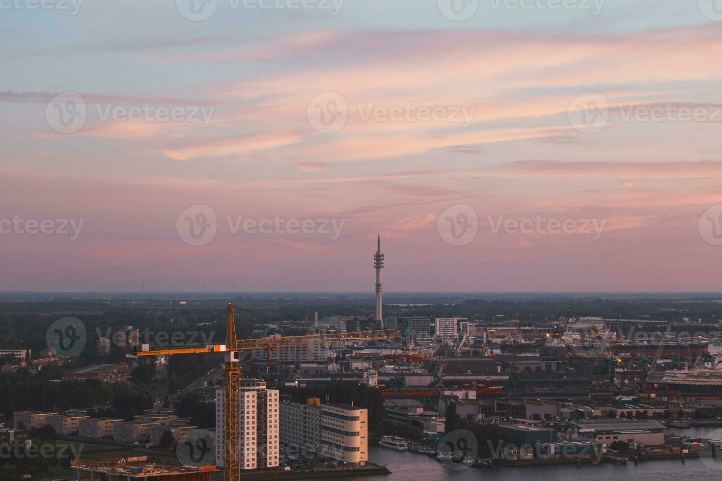 Aerial view of nightlife in the modern city of Rotterdam in the Netherlands. Red glow from the setting sun in the background photo