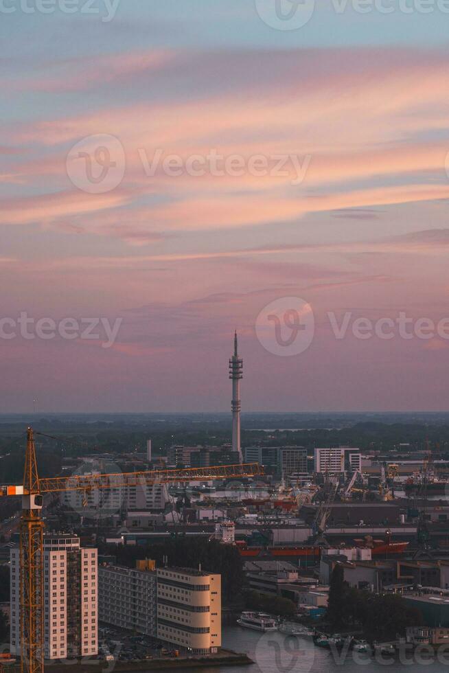 Aerial view of nightlife in the modern city of Rotterdam in the Netherlands. Red glow from the setting sun in the background photo