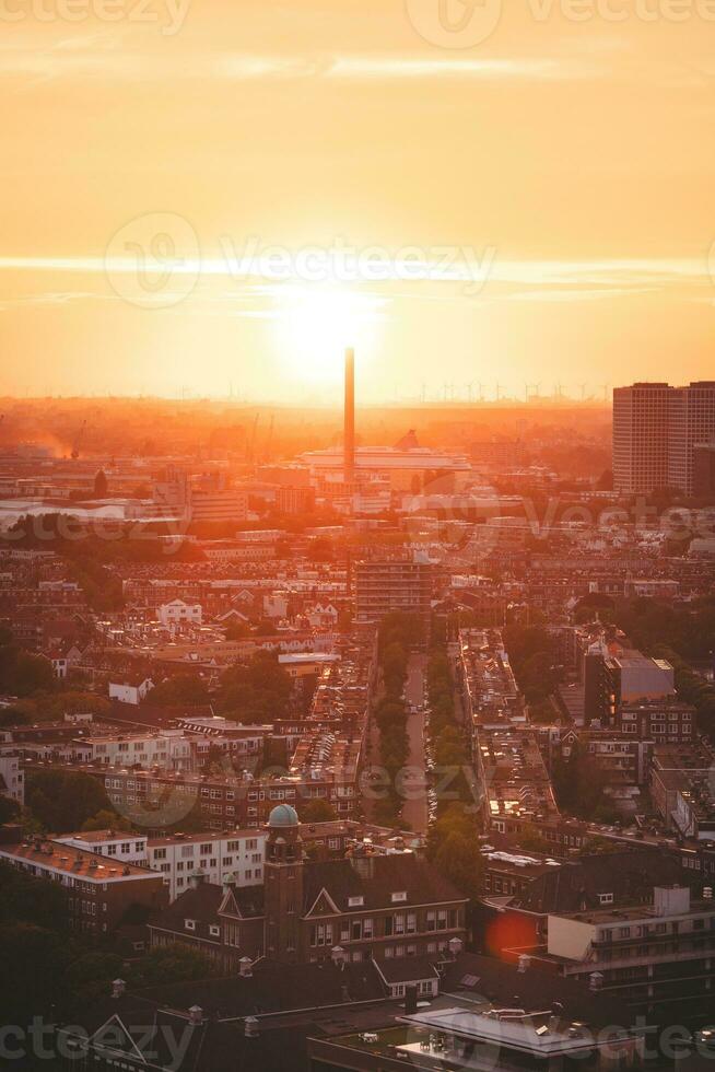 Dom ajuste terminado el horizonte en Róterdam. rojo ligero irradiación de el viento granja y el puerto. puesta de sol en Países Bajos foto