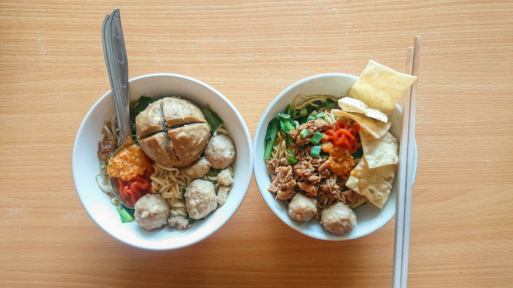 noodles and meatballs ready to be served on a table with a wooden texture photo
