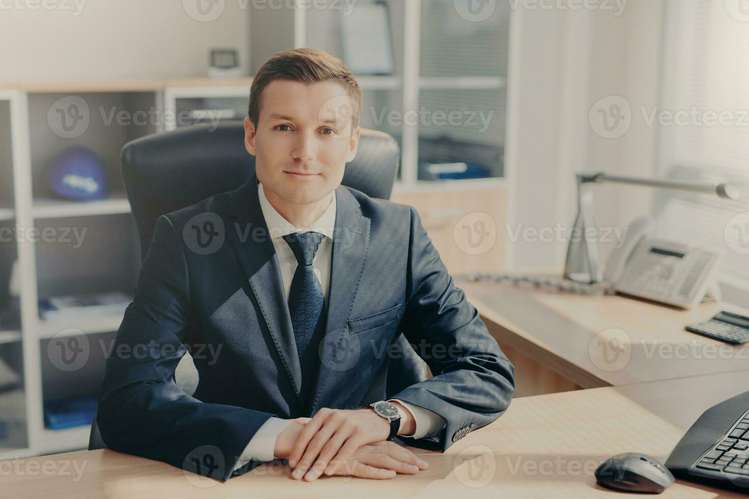 Confident businessman at desk in a sleek office photo