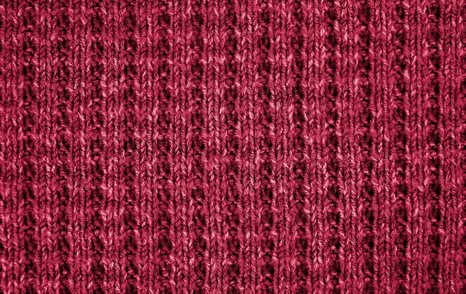 Texture of knitted wool fabric colored in the color of the Year 2023 Viva Magenta 18-1750. Banner. Top view. Close-up. Selective focus. photo