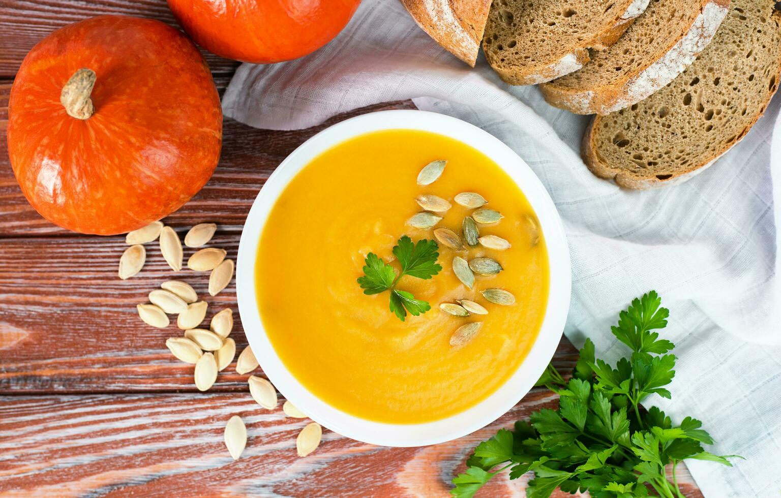 delicioso y sano calabaza crema sopa y hecho en casa recién horneado centeno un pan en el mesa. de cerca. parte superior vista. foto