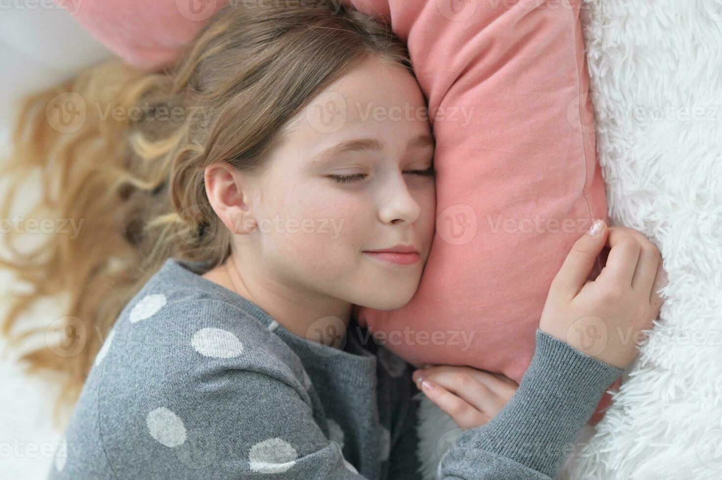 Sweet little girl sleeping in a bed photo