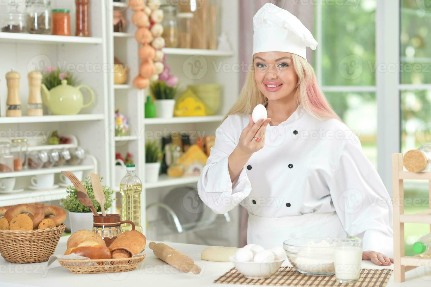 hermosa joven mujer en cocineros sombrero horneando a hogar foto