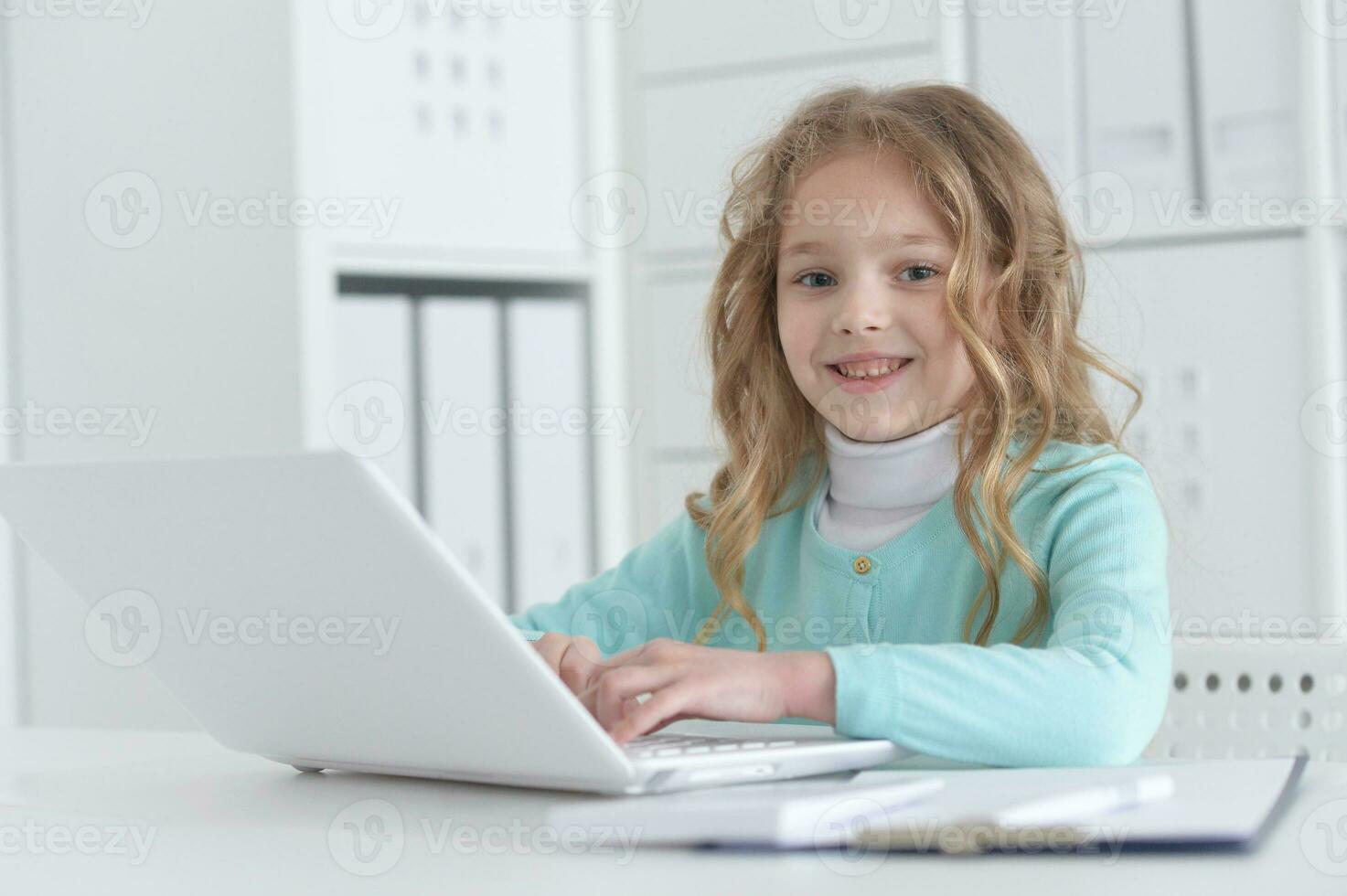 Cute and happy little girl children using laptop computer photo