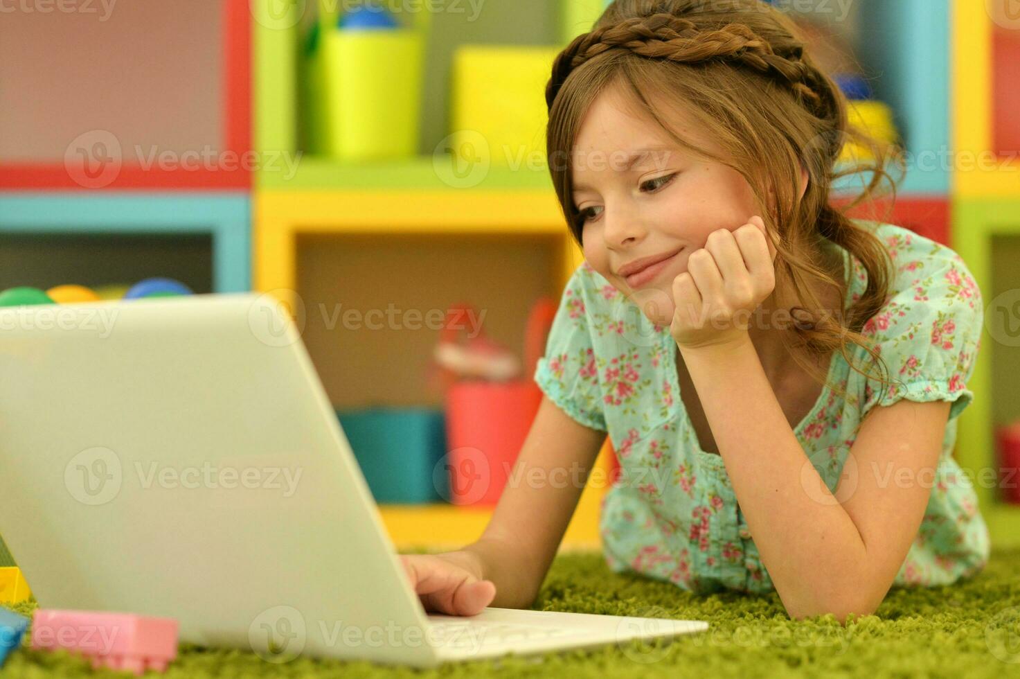 Cute and happy little girl children using laptop computer photo