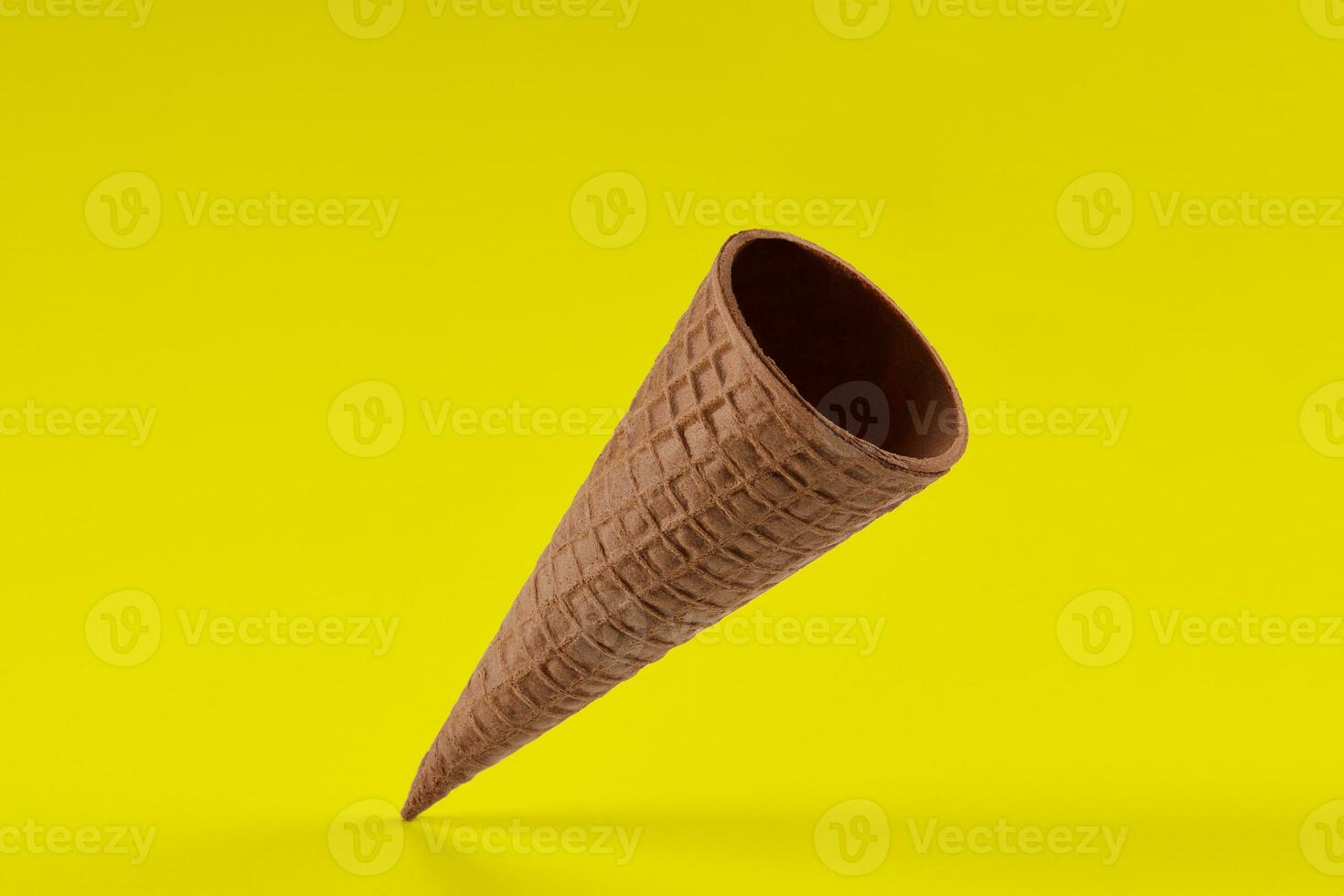 Empty, tasty wafer cone for ice cream against yellow background. Concept of food, treats. Mockup, template for your advertising and design. Close up photo