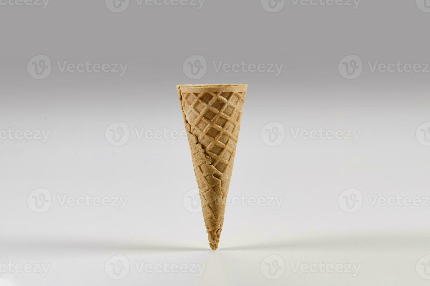 Empty small wafer cone for ice cream isolated on white. Concept of food, treats. Mockup, template for your advertising and design. Close up photo