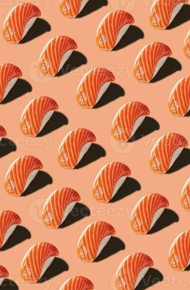 Food pattern of nigirizushi with salmon on pinkish background photo