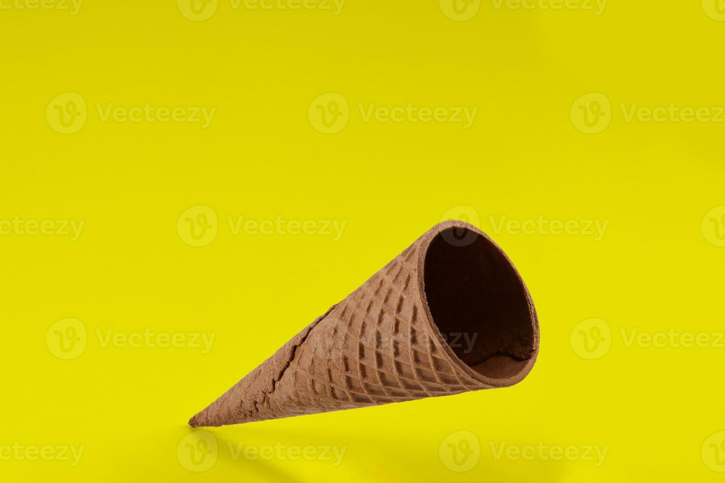 Empty wafer cone for ice cream against yellow background. Concept of food, treats. Mockup, template for your advertising and design. Close up photo