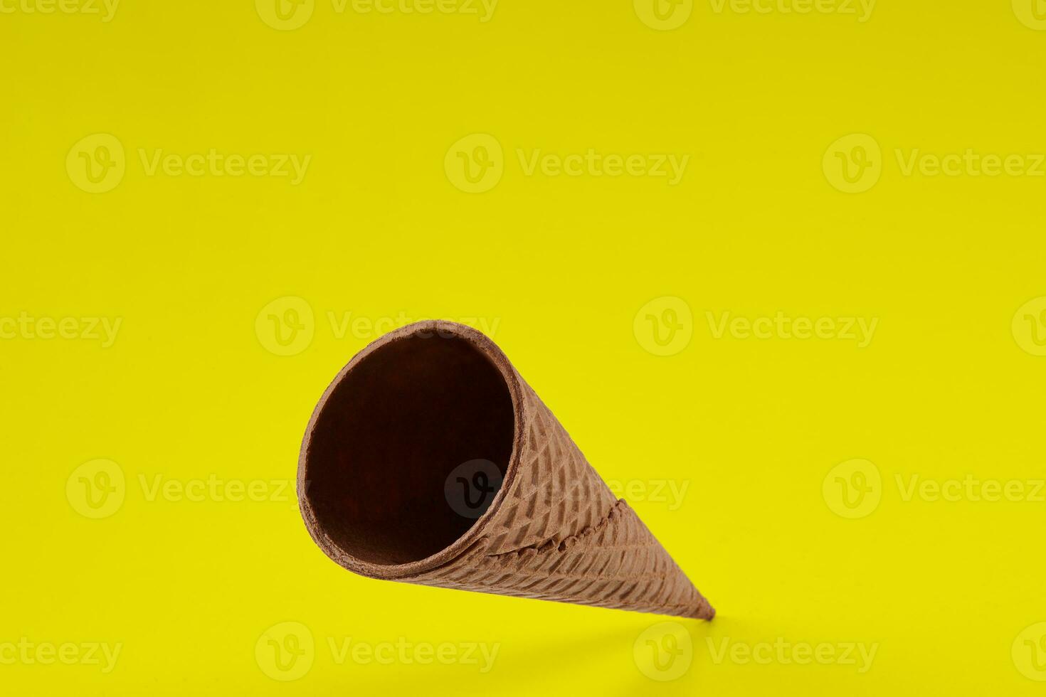 Empty, yummy wafer cone for ice cream against yellow background. Concept of food, treats. Mockup, template for your advertising and design. Close up photo