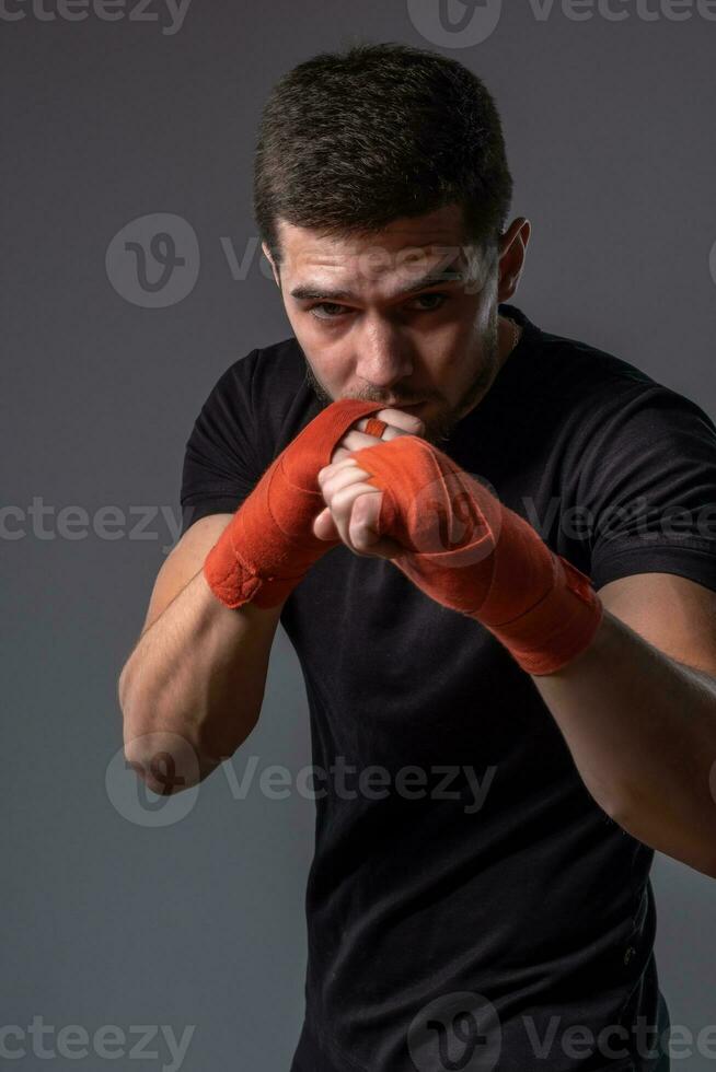 Sporty man with hands wraps standing in orthodox fighting stance photo