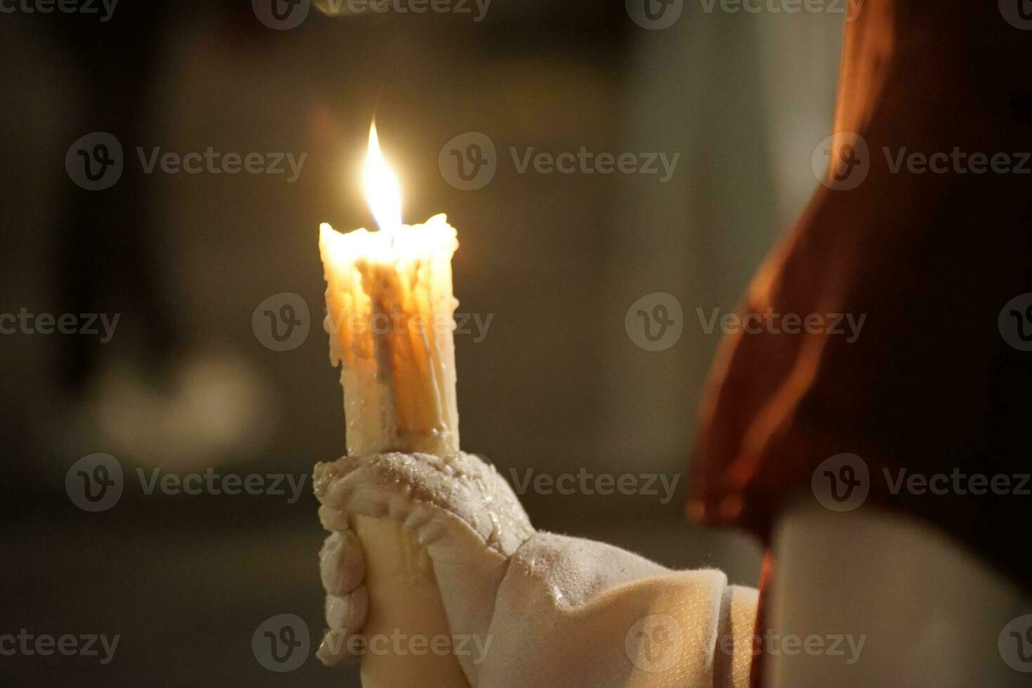 hermosa imagen de un nazareno y su vela en procesión foto