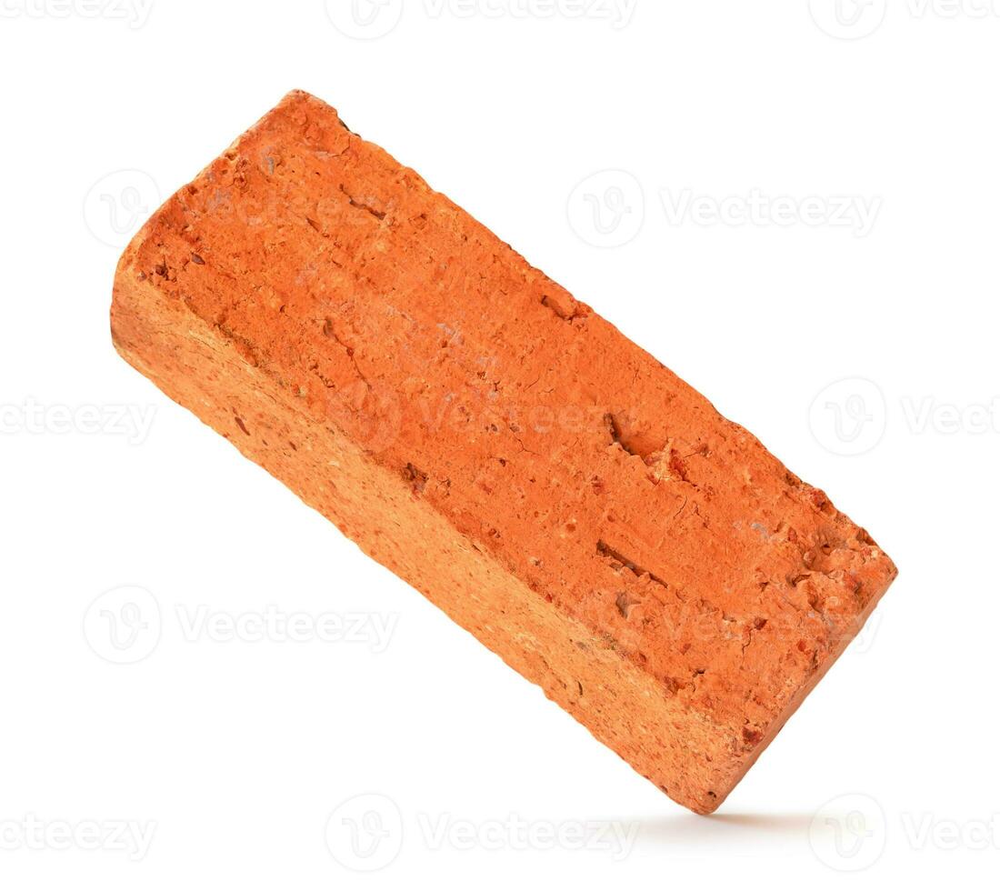 Single cracked old red or orange brick isolated on white background with clipping path photo