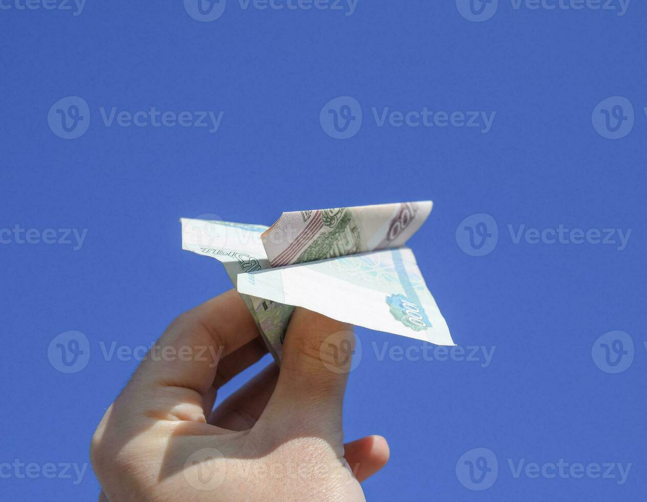 Denominations of Russian money, folded in the airplane against t photo