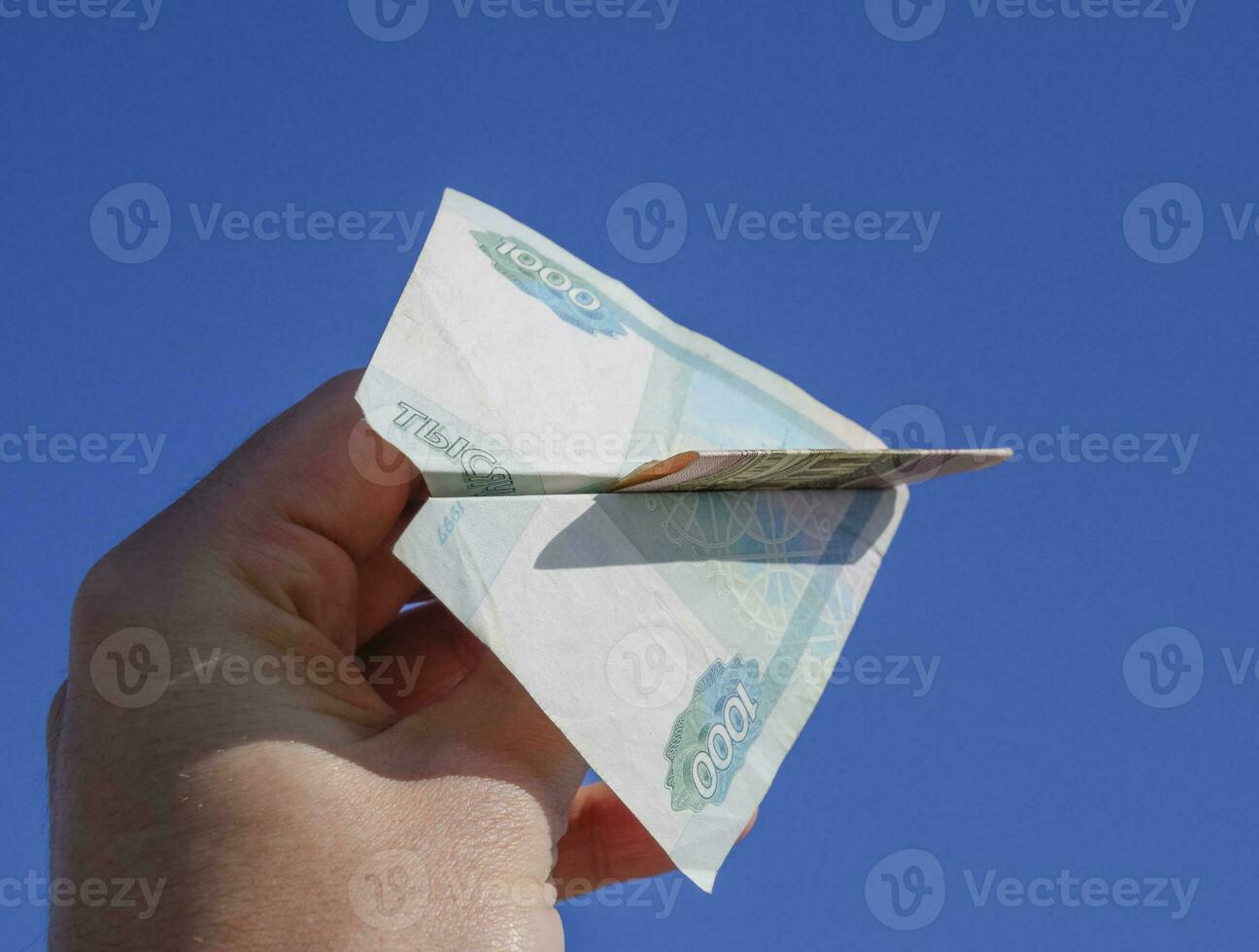 Denominations of Russian money, folded in the airplane against t photo