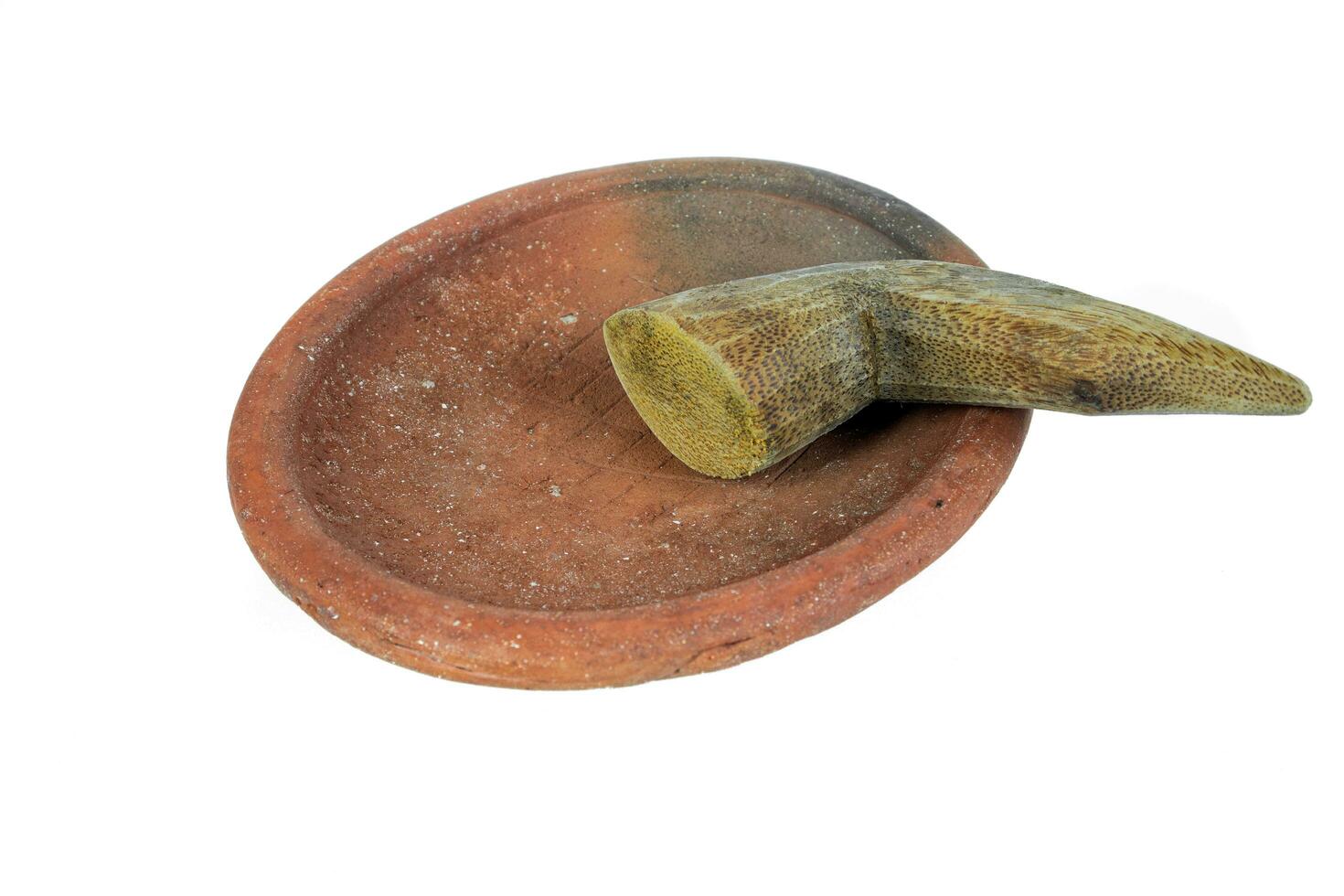Traditional mortar and pestle made of clay and wood on a white background photo