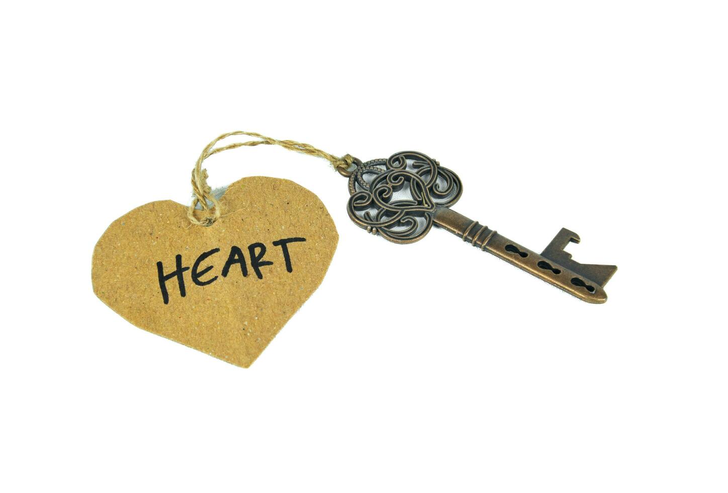 Old key with heart tag isolated on white background photo