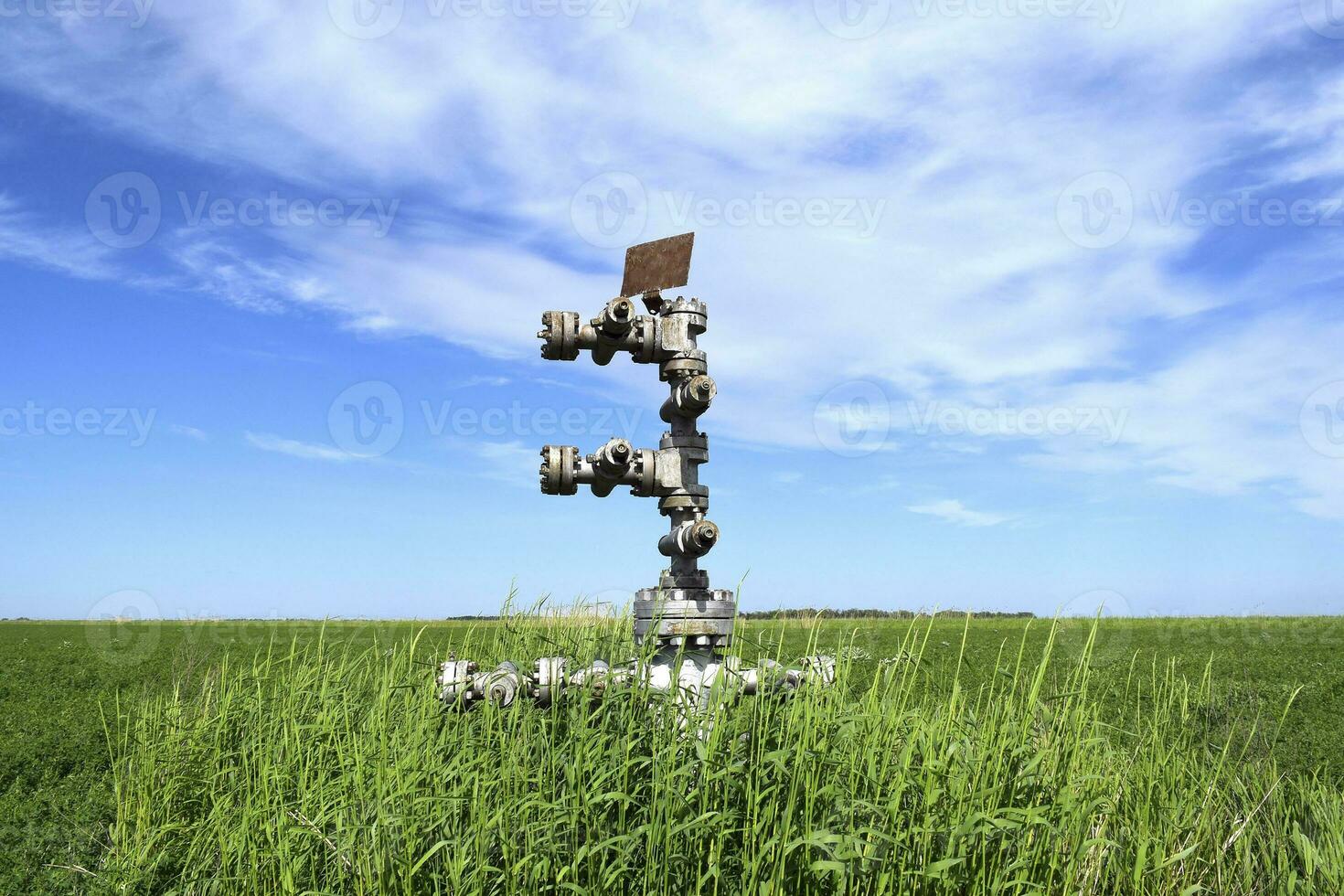 Enlatado petróleo bien en contra el cielo y campo foto