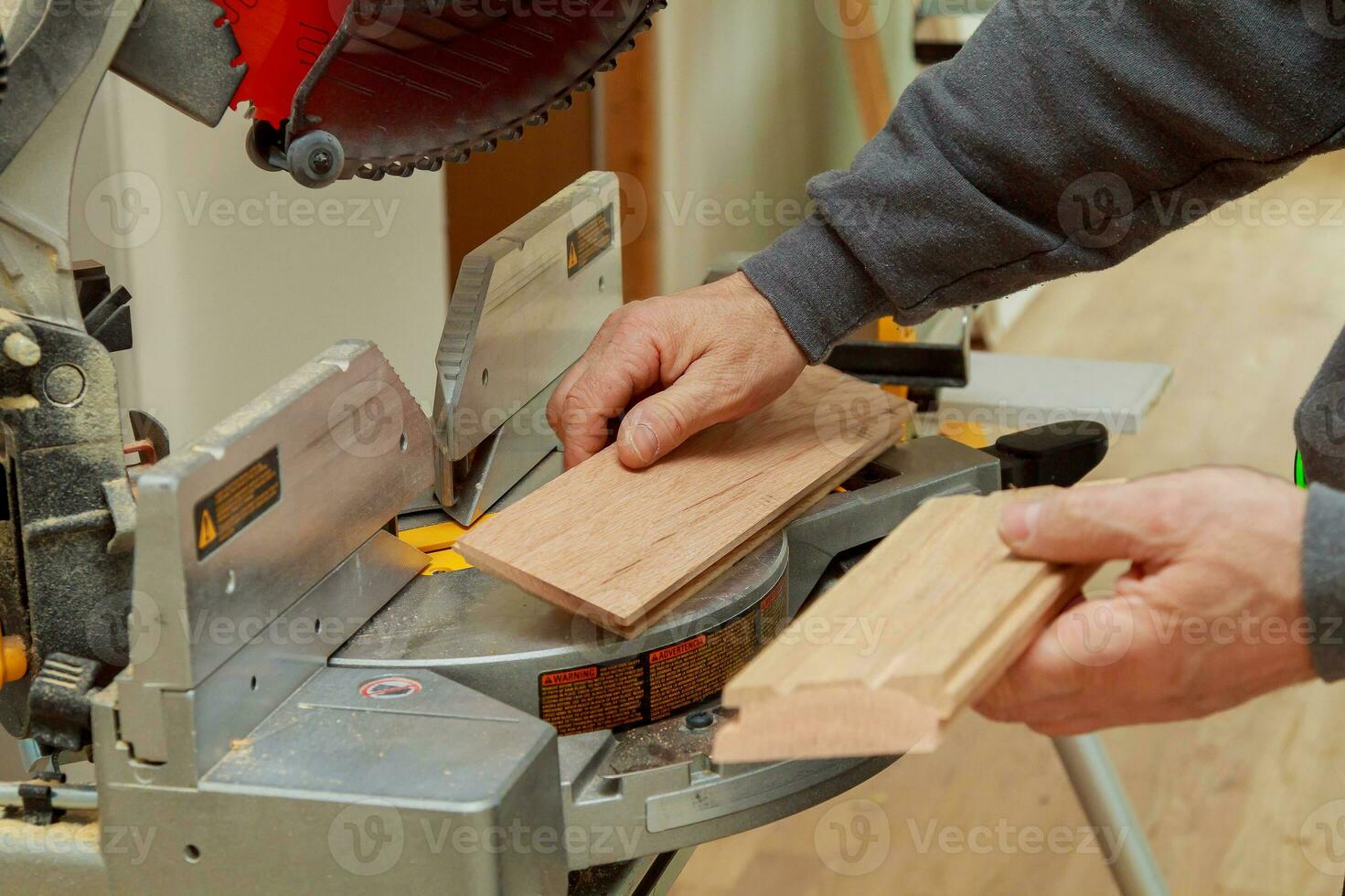 Construction worker, Trimming parquet on using circular miter saw cutting photo