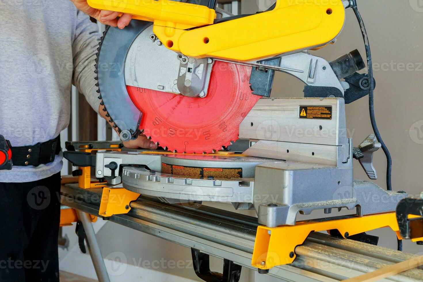 man cutting wood on electric saw photo