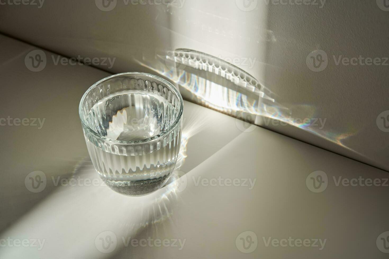 A glass of clean drinking water in the morning sun. photo