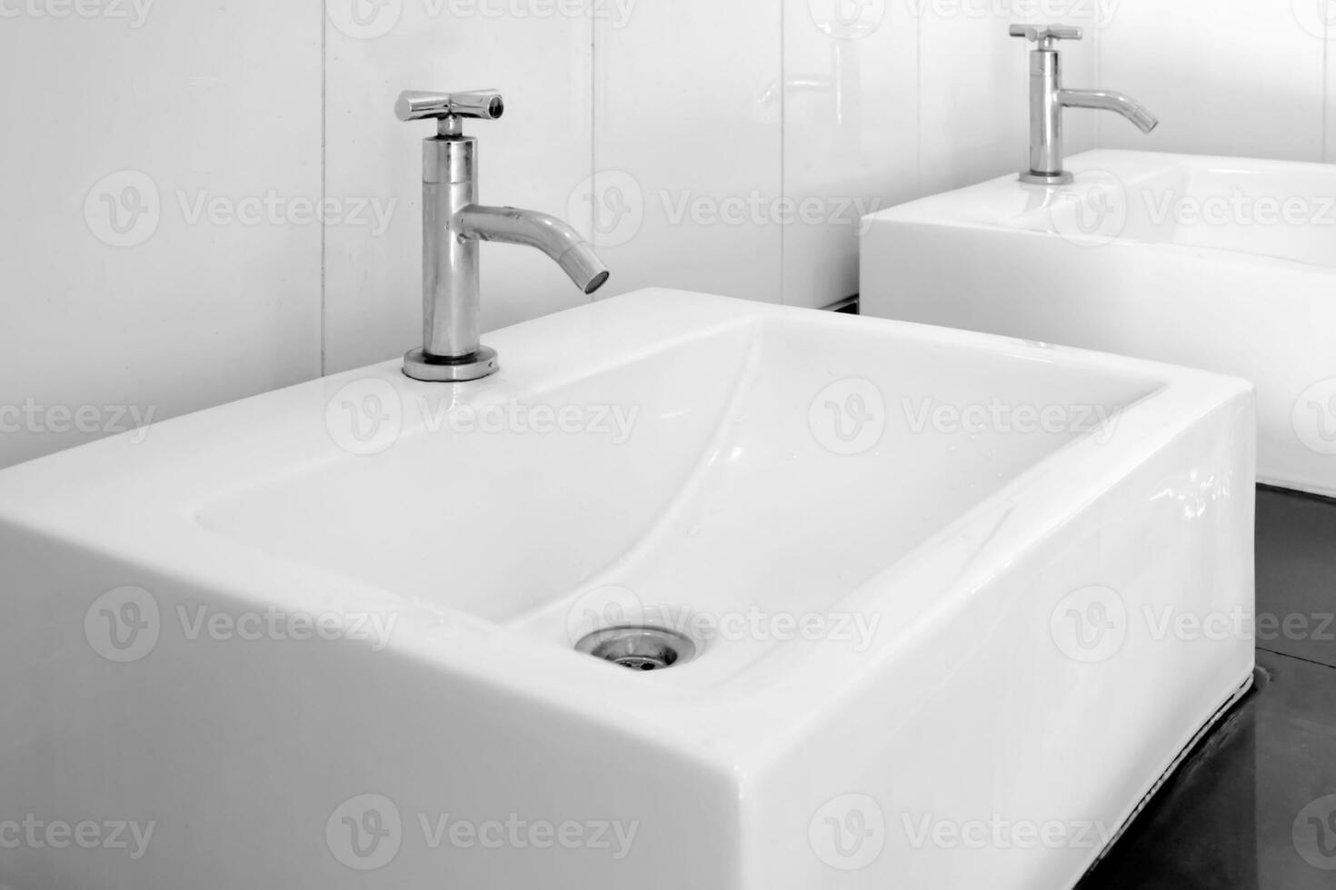 Black and white image close-up of porcelain square basin in bathroom. photo
