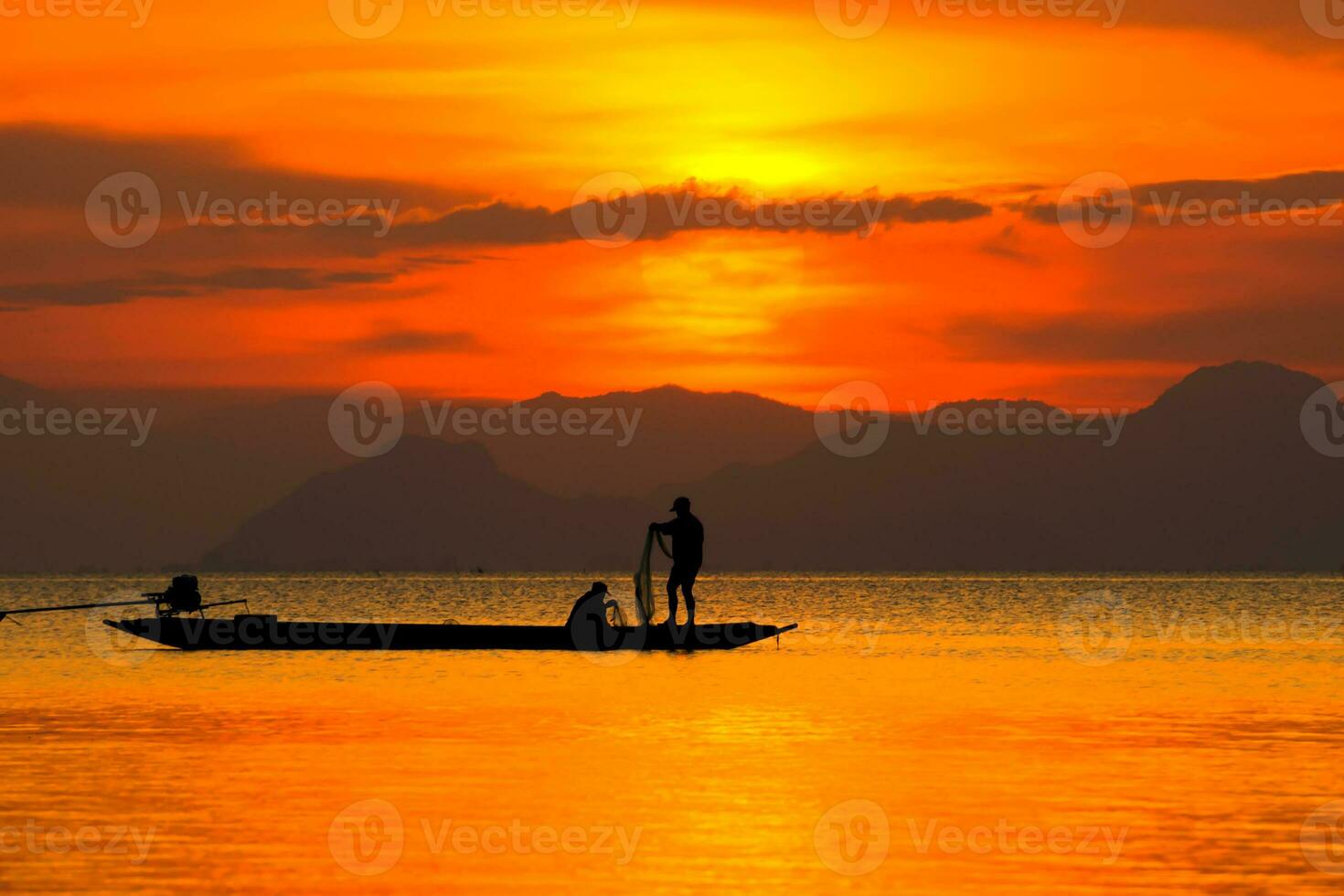 Silhouettes of fisherman at the lake with sunset, Thailand. photo