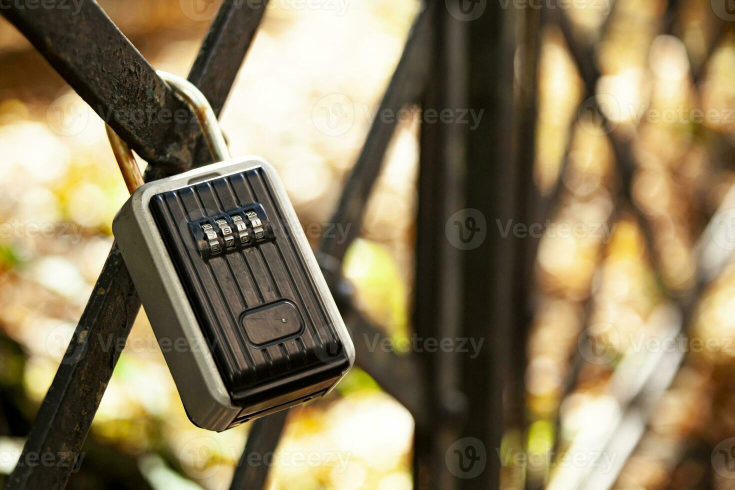 There's a black coded lock hanging on the fence. Private area with limited access. Protected gated area. photo