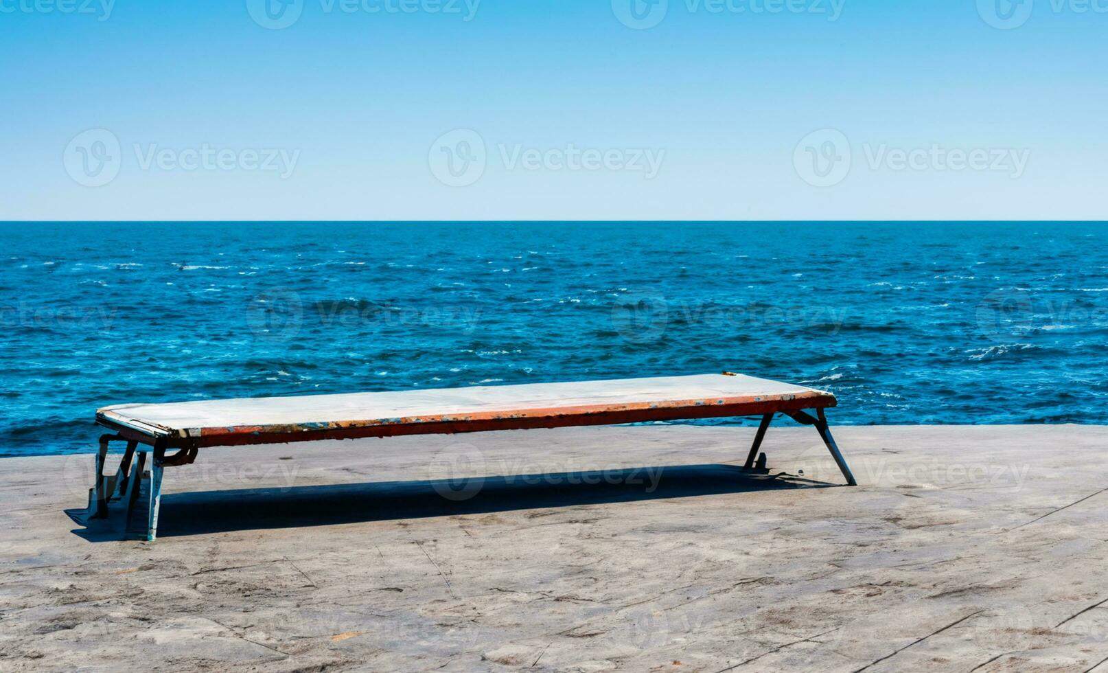 AI generated a stone bench sitting on top of a wall overlooking the ocean photo